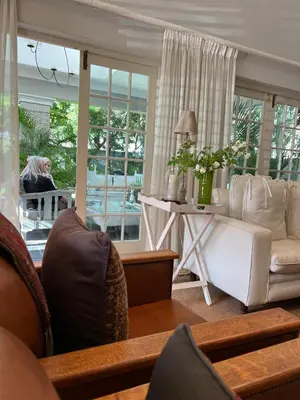a woman sitting at a table in a living room at Sandpipers in Hermanus