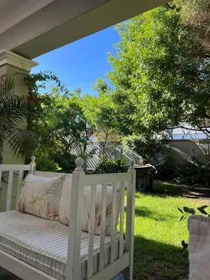 a white bench sitting on the porch of a house at Sandpipers in Hermanus