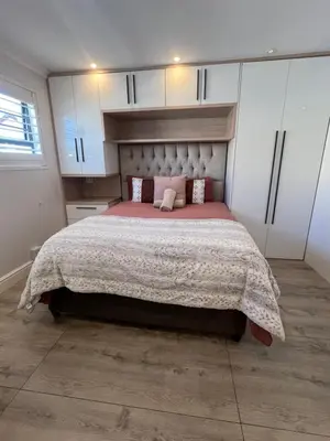 a bedroom with a large bed and white cabinets at Luxurious 12 sleeper Appaloosa Villa in Cape Town