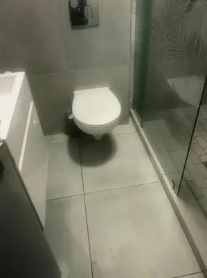 a bathroom with a toilet and a glass shower at Ocean Palace Table View in Cape Town