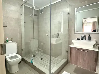 a bathroom with a shower and a toilet and a sink at 6 sleeper apartment near Canal Walk in Cape Town