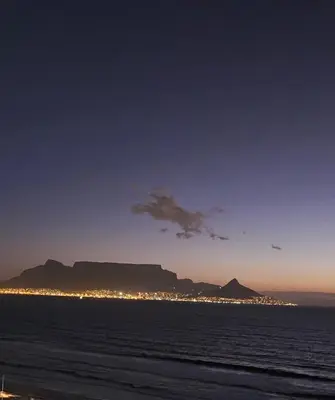 a view of table mountain from the beach at night at Beachside Getaway in Cape Town
