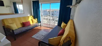 a living room with a couch and a window with a view at Unit 75 Hermanus Beach Club in Hermanus