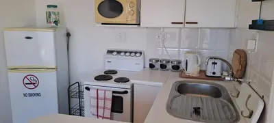 a small kitchen with a sink and a refrigerator at Unit 75 Hermanus Beach Club in Hermanus