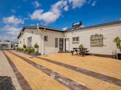 an outdoor patio with a table and a building at La Bella Vida Self Catering Apartments in Bellville