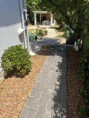 a garden with a brick walkway next to a house at Table View Lodge in Cape Town