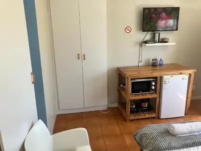 a kitchen with a white refrigerator and a microwave at Table View Lodge in Cape Town