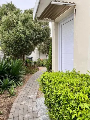 a walkway in front of a house with bushes at Table View Lodge in Cape Town