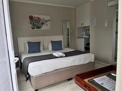a bedroom with a large bed with blue pillows at Table View Lodge in Cape Town