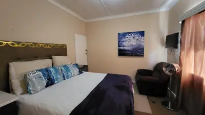a bedroom with a large bed and a chair at The Vasco in Cape Town