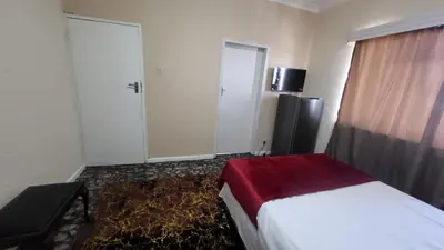 a hotel room with a bed and a refrigerator at The Vasco in Cape Town