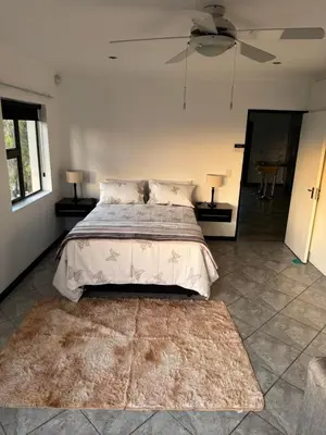 a bedroom with a bed and a rug at Shalom in Cape Town