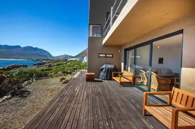 a house with a deck with a view of the ocean at Villa Sur La Mer in Pringle Bay