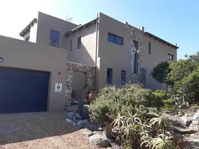 a large white house with a garage at Villa Sur La Mer in Pringle Bay