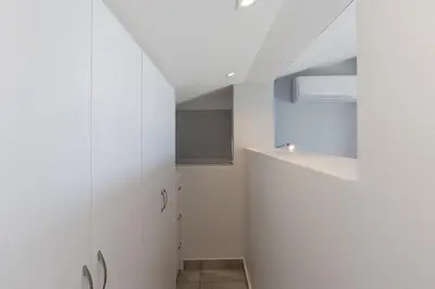 a room with white walls and a white cabinet at 34 Gordonia, Beachfront Penthouse in Gordonʼs Bay