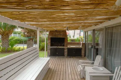 a screened porch with a fireplace on a house at The Ocean Side Cottage in Cape Town