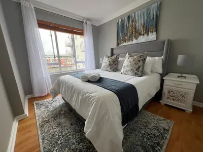 a bedroom with a large white bed with a window at Tyger waterfront apartment in Cape Town