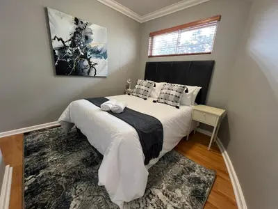 a bedroom with a large bed with white sheets and pillows at Tyger waterfront apartment in Cape Town
