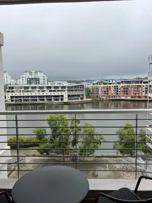 a balcony with a view of a river and buildings at Tyger waterfront apartment in Cape Town