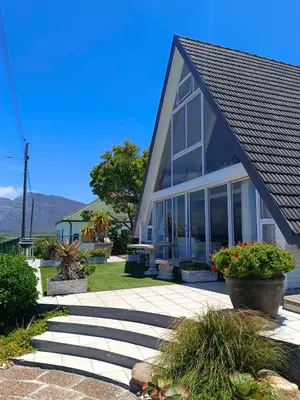 a house with large windows and a patio at Scenic Bliss Holiday Home in Kleinmond