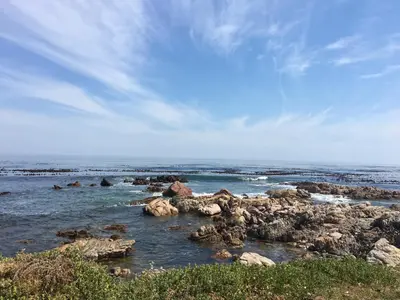 a group of rocks in the water on a beach at Onrus Beach House in Hermanus