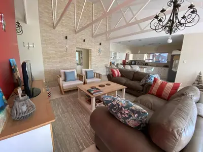 a living room with a couch and a table at Onrus Beach House in Hermanus