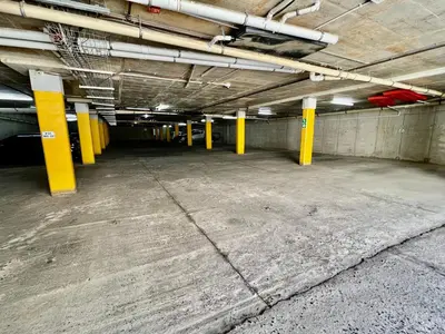 an empty parking lot with yellow columns in a parking garage at 7 on Huis Piron in Stellenbosch