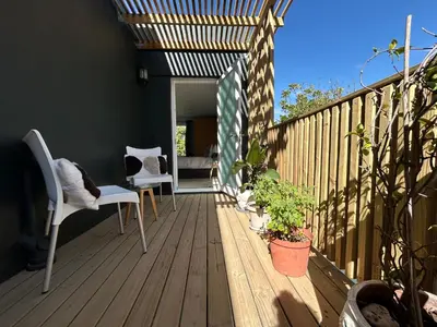 a wooden deck with chairs and plants on it at Sunset Studios in Cape Town