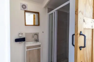 a bathroom with a sink and a shower at Penguin's Nest in Bettyʼs Bay
