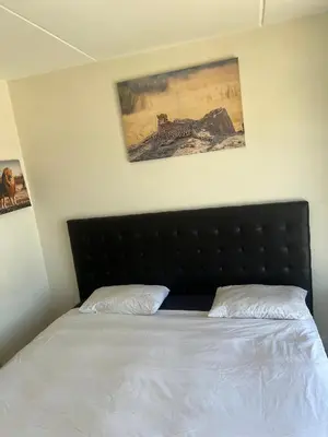 a bed with a black headboard in a bedroom at Sunny Escapes Rentals in Cape Town
