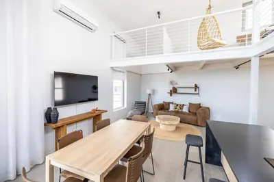 a living room with a wooden table and a couch at Ocean 9 - Sunset Beachfront Apartments in Cape Town