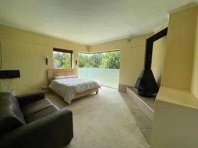 a bedroom with a bed and a tv and a couch at Basco River Lodge Holiday Villa in Grabouw