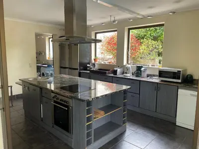 a kitchen with a large island in the middle at Basco River Lodge Holiday Villa in Grabouw