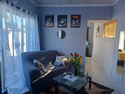 a blue living room with a couch and a table at Oakway Guest Suite in Cape Town