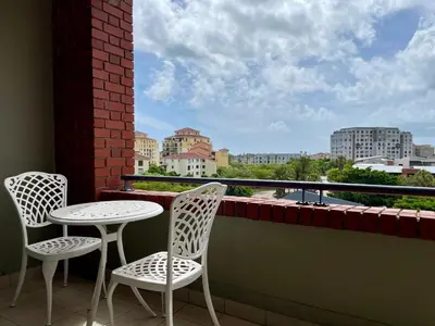 two chairs and a table on a balcony with a view at Studio in the City in Cape Town