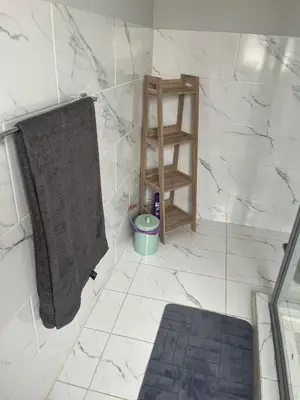 a bathroom with a gray towel and a shelf at Annebella's in Gordonʼs Bay