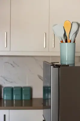 a container of utensils sitting on top of a refrigerator at Annebella's in Gordonʼs Bay
