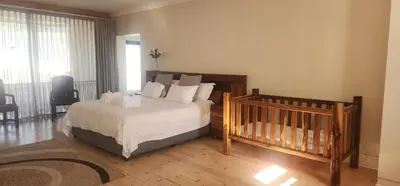 a bedroom with a bed and a crib in it at Stellenbosch Paradijs Family-home in Stellenbosch