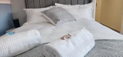 a white bed with pillows and towels on it at Stellenbosch Paradijs Family-home in Stellenbosch