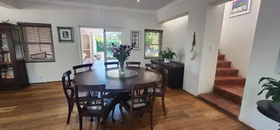 a dining room with a table and chairs and stairs at Stellenbosch Paradijs Family-home in Stellenbosch