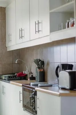 a kitchen with white cabinets and a counter top at The Berna in Cape Town