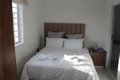 a bed with two towels sitting on top of it at one bedroom apartment A1 in Cape Town