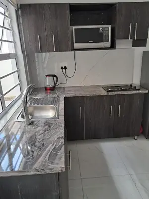 a kitchen with a sink and a microwave at one bedroom apartment A1 in Cape Town