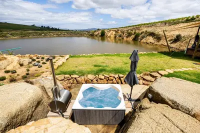an umbrella sitting on rocks next to a river at Amperbo Glamping in Cape Town