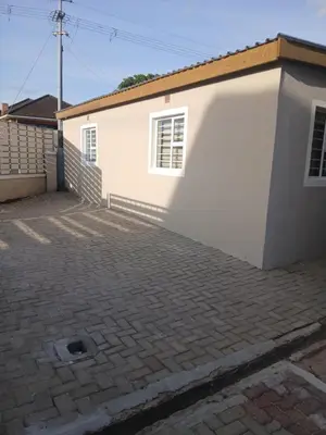 a white house with a brick driveway at One Bedroom Apartment A4 in Cape Town