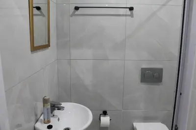 a white bathroom with a sink and a shower at One Bedroom Apartment A4 in Cape Town