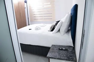 a small bedroom with a bed and a table at One Bedroom Apartment A4 in Cape Town