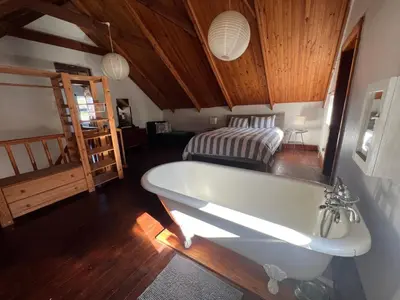 a bath tub in a room with a bed at 9de Laan Kleinmond in Kleinmond