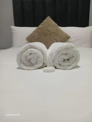 a pair of rolled towels on a bed at The Gem Guest House & Spa in Parow