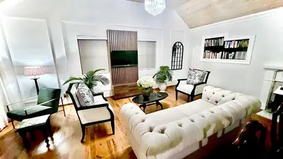 a living room with a white couch and chairs at Vendôme in Somerset West